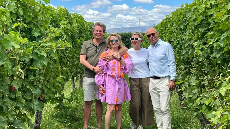 Four friends posing in a lush green vineyard in Marlborough.