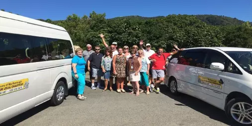 Tour group standing beside Your Local Chauffeur vans in Marlborough.