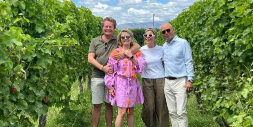 Four friends posing in a lush green vineyard in Marlborough.