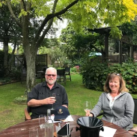 Couple enjoying wine tasting in a relaxed Marlborough garden setting