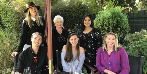 Happy wine tour group enjoying a garden tasting experience in Marlborough