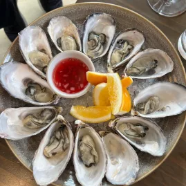 Plate of fresh New Zealand oysters served on ice with lemon and vinaigrette