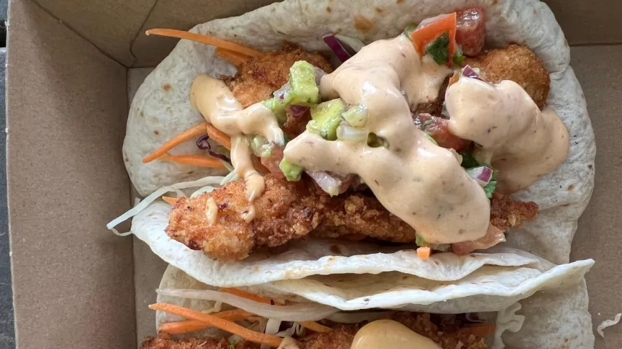 Crispy fish tacos with slaw and creamy dressing served in a takeaway box