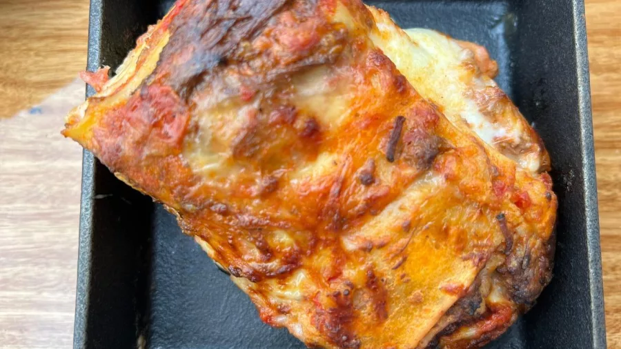 Homestyle baked lasagne with golden melted cheese in a cast iron dish