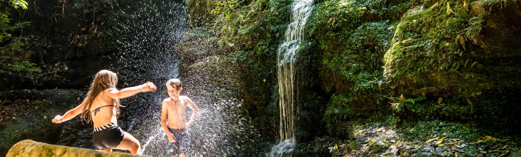 Children playing at Ship Cove Waterfall in Queen Charlotte Sound, Marlborough