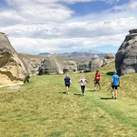 Group walking among massive limestone formations at Elephant Rocks near Duntroon, New Zealand.