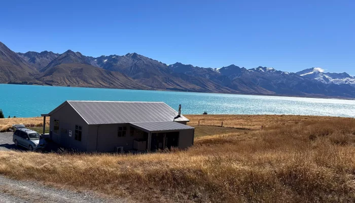 Scenic lodge at Braemar Station overlooking the turquoise waters of Lake Pukaki with snow-capped mountains in the background.
