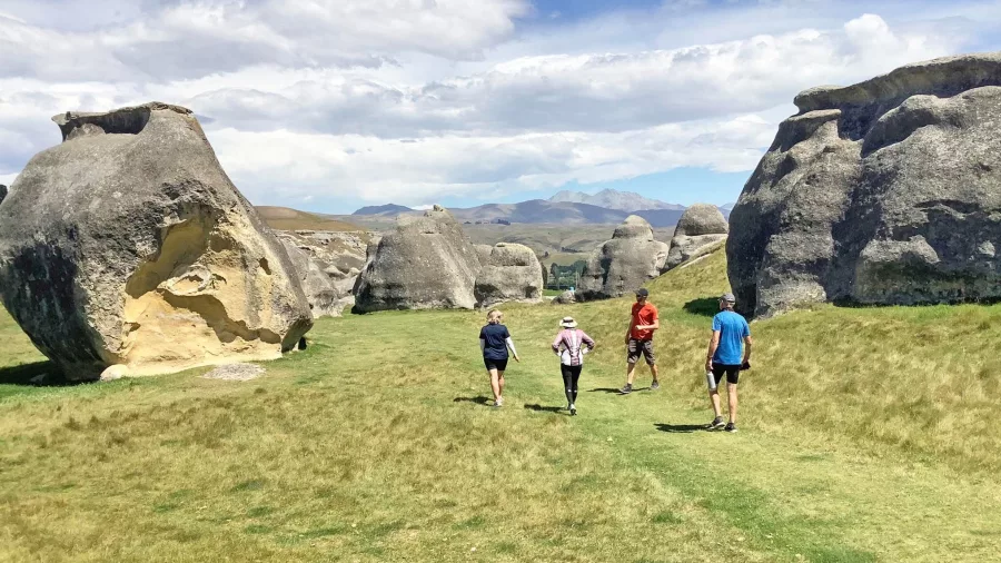 Group walking among massive limestone formations at Elephant Rocks near Duntroon, New Zealand.