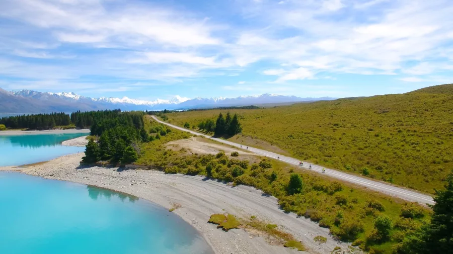 Cyclists riding along the Alps to Ocean Trail beside Lake Pukaki with mountain views in New Zealand
