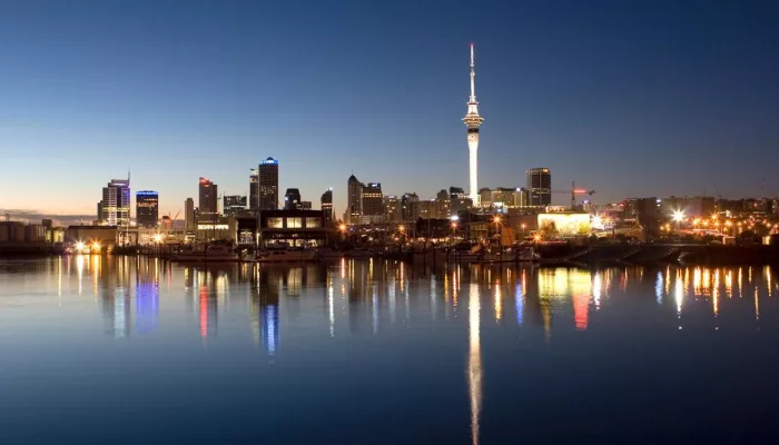 Auckland city skyline with the Sky Tower reflecting in the harbour at dusk