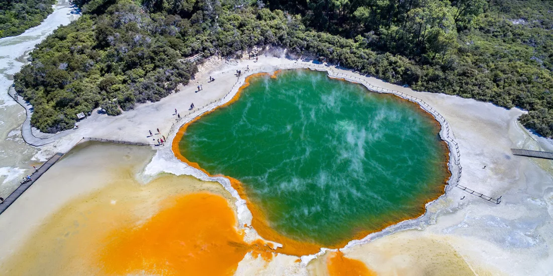 Aerial view of Champagne Pool at Wai-O-Tapu Thermal Wonderland in Rotorua, with vibrant orange and green geothermal colours.