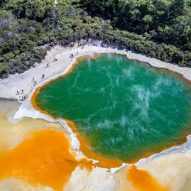 Aerial view of Champagne Pool at Wai-O-Tapu Thermal Wonderland in Rotorua, with vibrant orange and green geothermal colours.