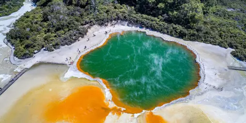 Aerial view of Champagne Pool at Wai-O-Tapu Thermal Wonderland in Rotorua, with vibrant orange and green geothermal colours.