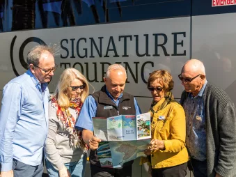 Tour captain showing map to Signature Coach passengers