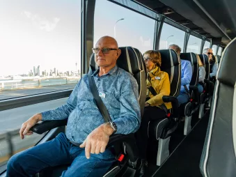 Passenger enjoying a window seat view on the Signature coach by Grand Pacific Tours