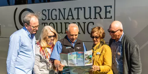 Tour captain showing map to Signature Coach passengers