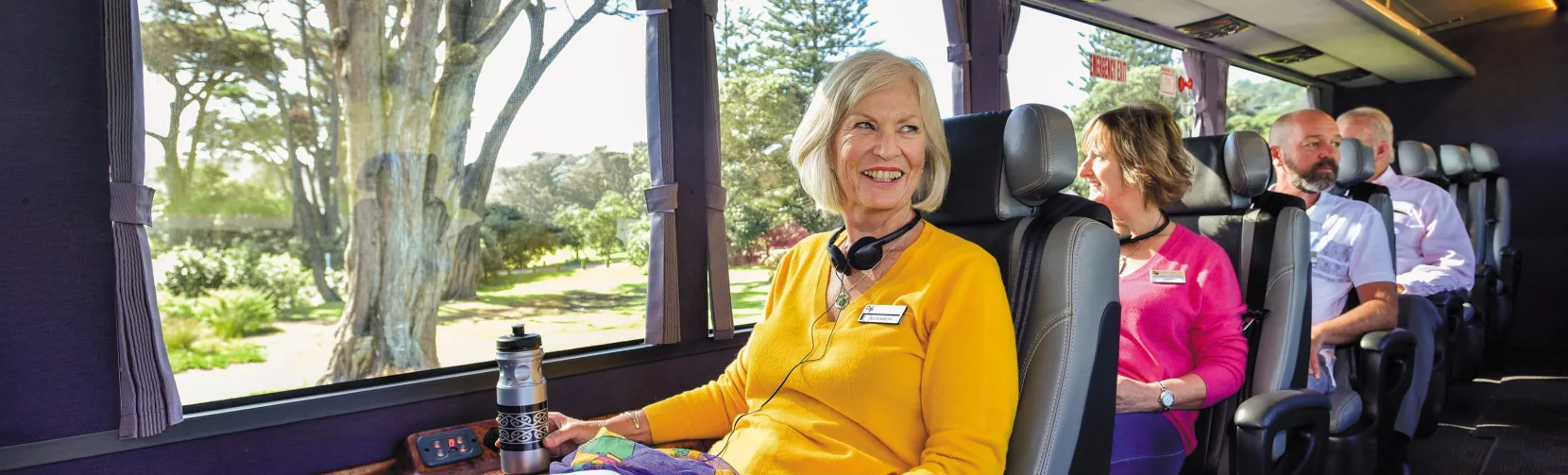 Passenger enjoying panoramic views from a spacious window seat on the Ultimate coach