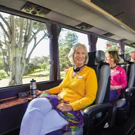 Passenger enjoying panoramic views from a spacious window seat on the Ultimate coach