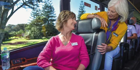 Two guests chatting inside the Ultimate coach with scenic views outside