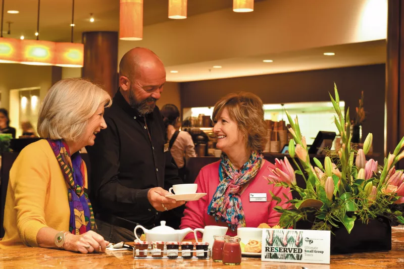 Guests enjoying friendly service at a café during an Ultimate coach tour