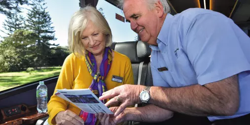 Grand Pacific coach captain showing a tour itinerary to a guest on board