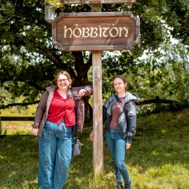 Visitors standing by the Hobbiton sign at the Hobbiton Movie Set, Matamata, New Zealand.