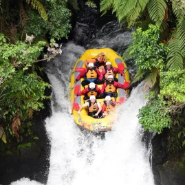 Group of travellers white water rafting down Tutea Falls on the Kaituna River, Rotorua, New Zealand.