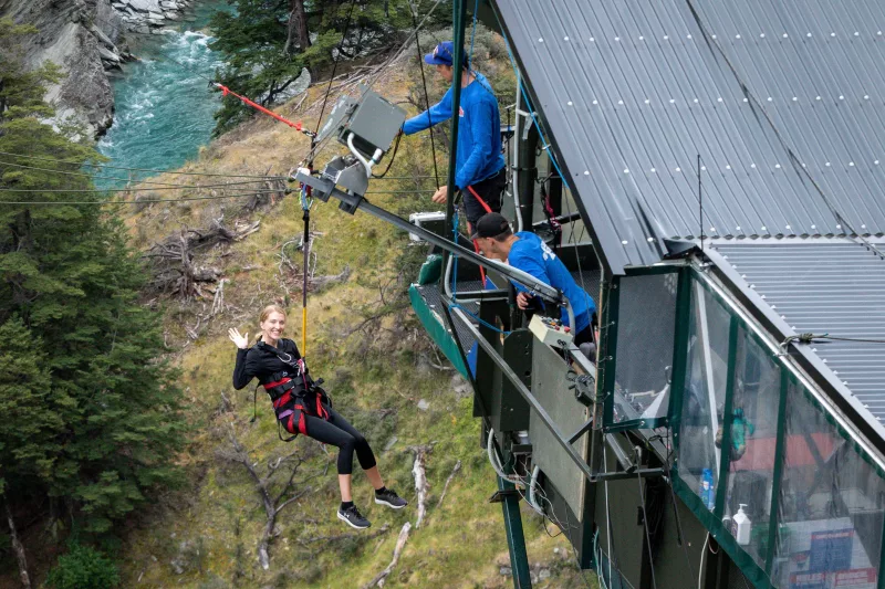 Traveller launching off the Queenstown Canyon Swing platform over the Shotover River, New Zealand.
