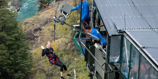 Traveller launching off the Queenstown Canyon Swing platform over the Shotover River, New Zealand.