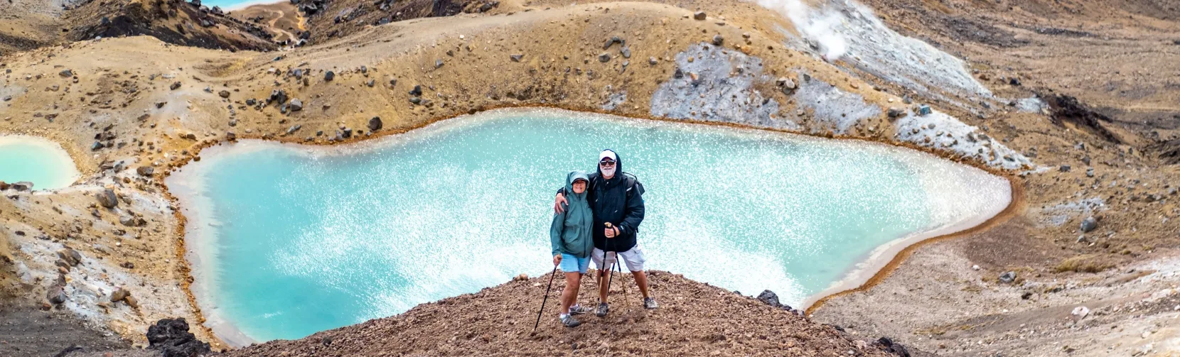 Hikers standing above the Emerald Lakes on the Tongariro Alpine Crossing
