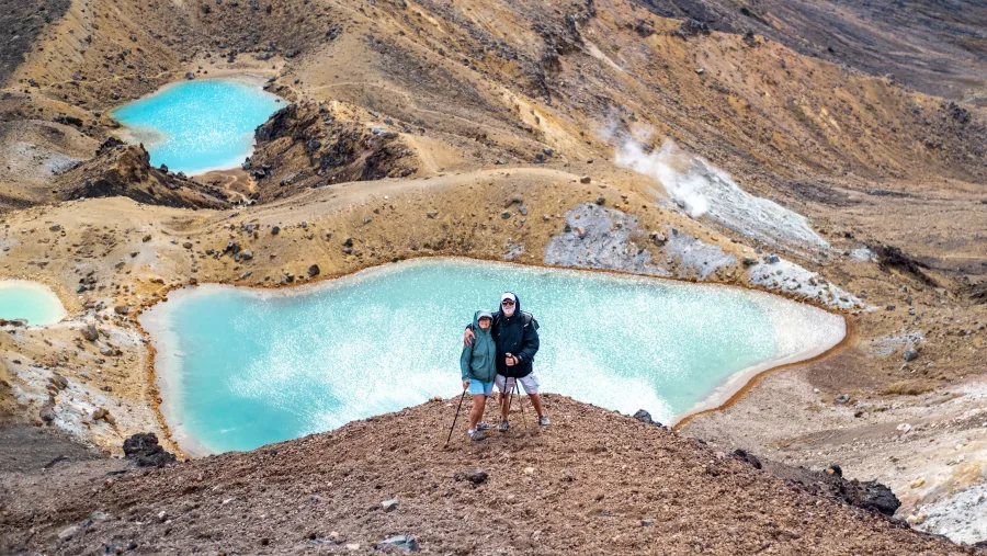 Hikers standing above the Emerald Lakes on the Tongariro Alpine Crossing