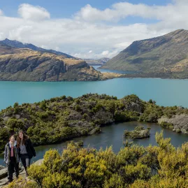 Hikers on Mou Waho Island overlooking Lake Wanaka and surrounding peaks