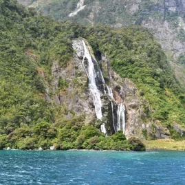 Waterfall cascading into Milford Sound from steep cliffs