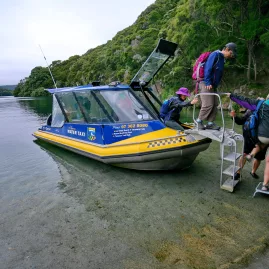 Hikers arriving via water taxi at Lake Tarawera for a walk near Rotorua