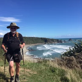 Man hiking the rugged Cape Foulwind coastal trail on the West Coast of New Zealand