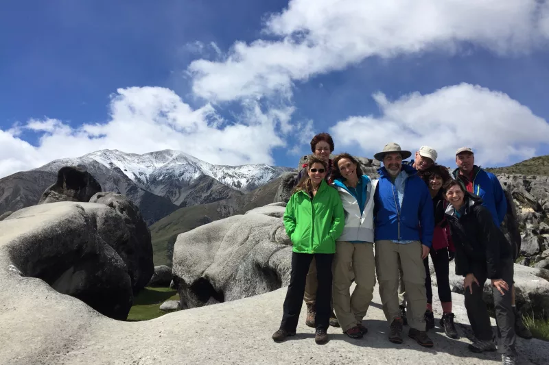 Tramping group posing among giant limestone boulders at Castle Hill in Canterbury