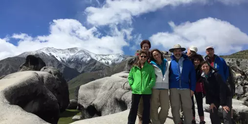 Tramping group posing among giant limestone boulders at Castle Hill in Canterbury