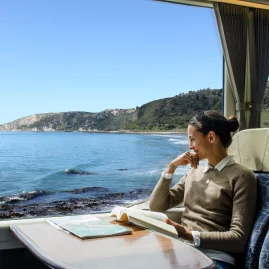 Woman enjoying sea view on Coastal Pacific train