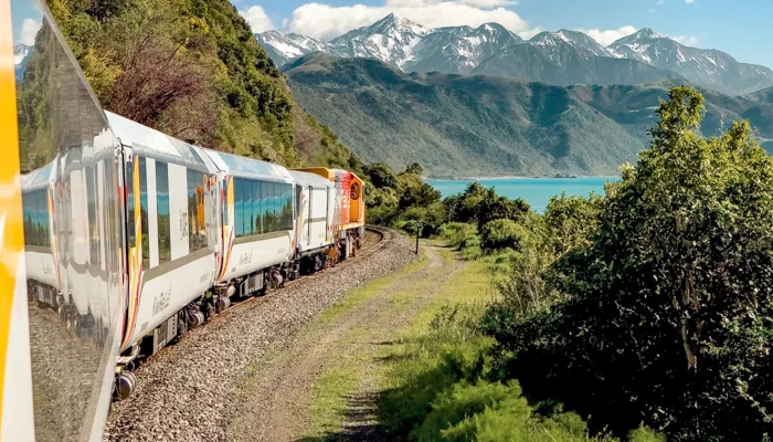 Coastal Pacific train passing through Canterbury with ocean and mountain views