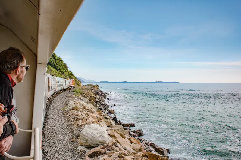 Passengers enjoying ocean views from the Coastal Pacific train along the Kaikōura coast