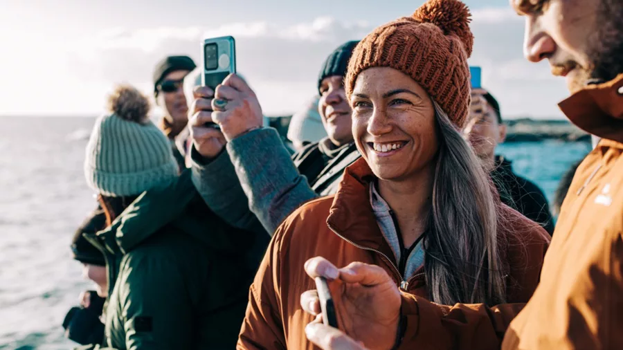 Smiling group of people whale watching near Kaikōura during a Coastal Pacific train journey