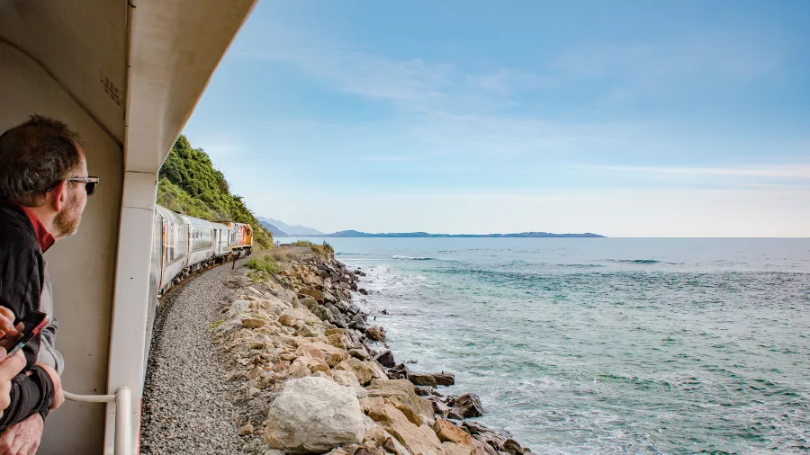 Passengers enjoying ocean views from the Coastal Pacific train along the Kaikōura coast