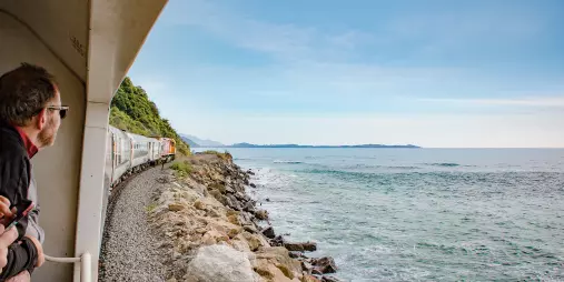 Passengers enjoying ocean views from the Coastal Pacific train along the Kaikōura coast
