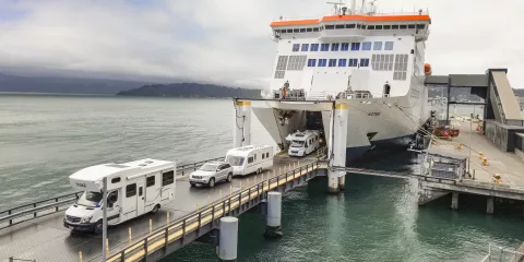 Campervans and vehicles disembark Interislander Kaitaki ferry in Picton