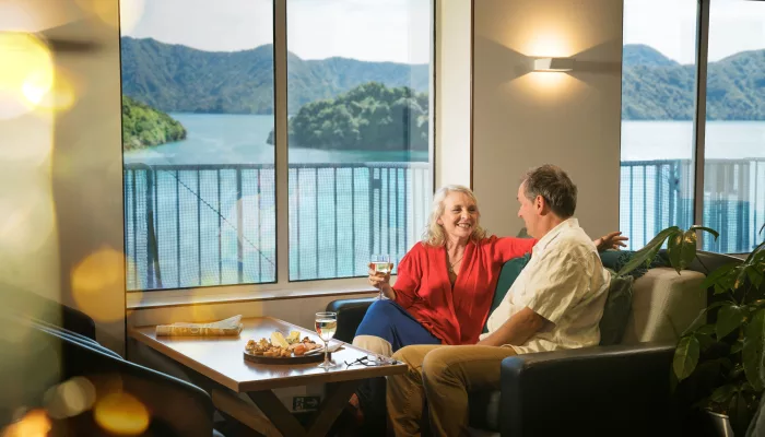 Couple enjoys drinks with ocean views in Interislander Premium Lounge
