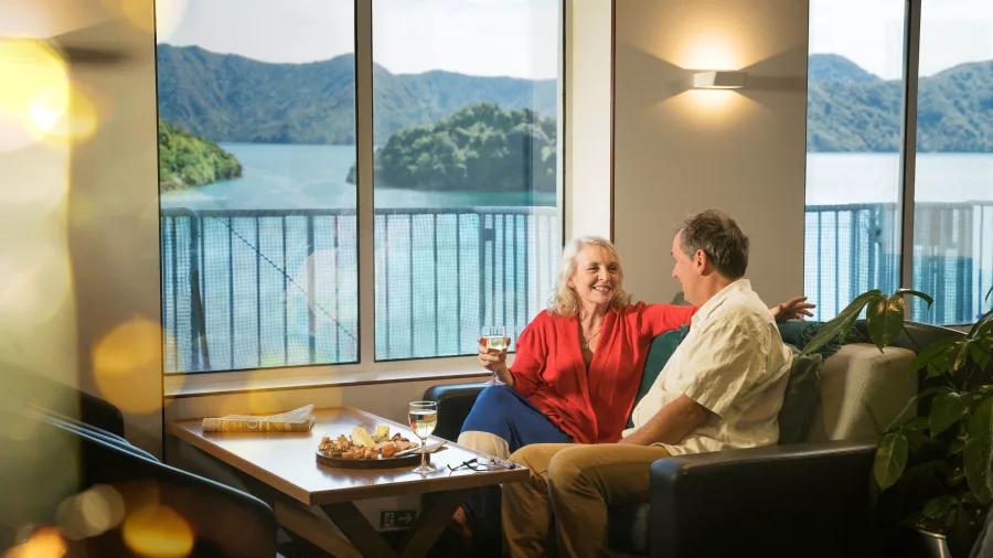 Couple enjoys drinks with ocean views in Interislander Premium Lounge