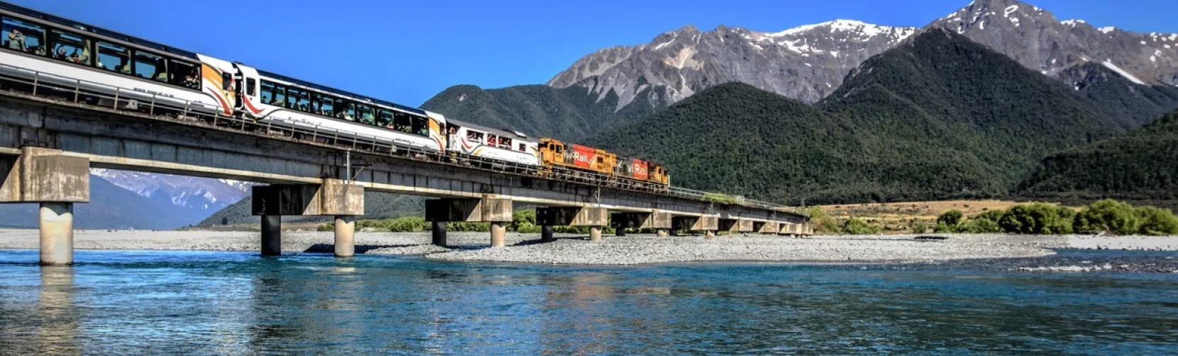 TranzAlpine train crossing Waimakariri River on a clear day
