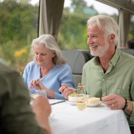 Couple enjoying lunch with views aboard TranzAlpine train