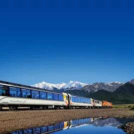 TranzAlpine train with Southern Alps reflected in water