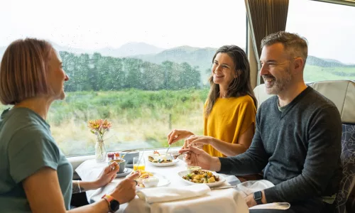 Friends dining in Scenic Plus carriage aboard the TranzAlpine